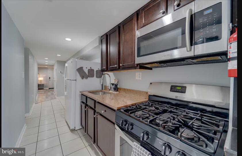 325 57th Street Northeast, Unit 21 Washington, DC 20019 - Photo 5 of 11 a kitchen with stainless steel appliances granite countertop a stove and a microwave