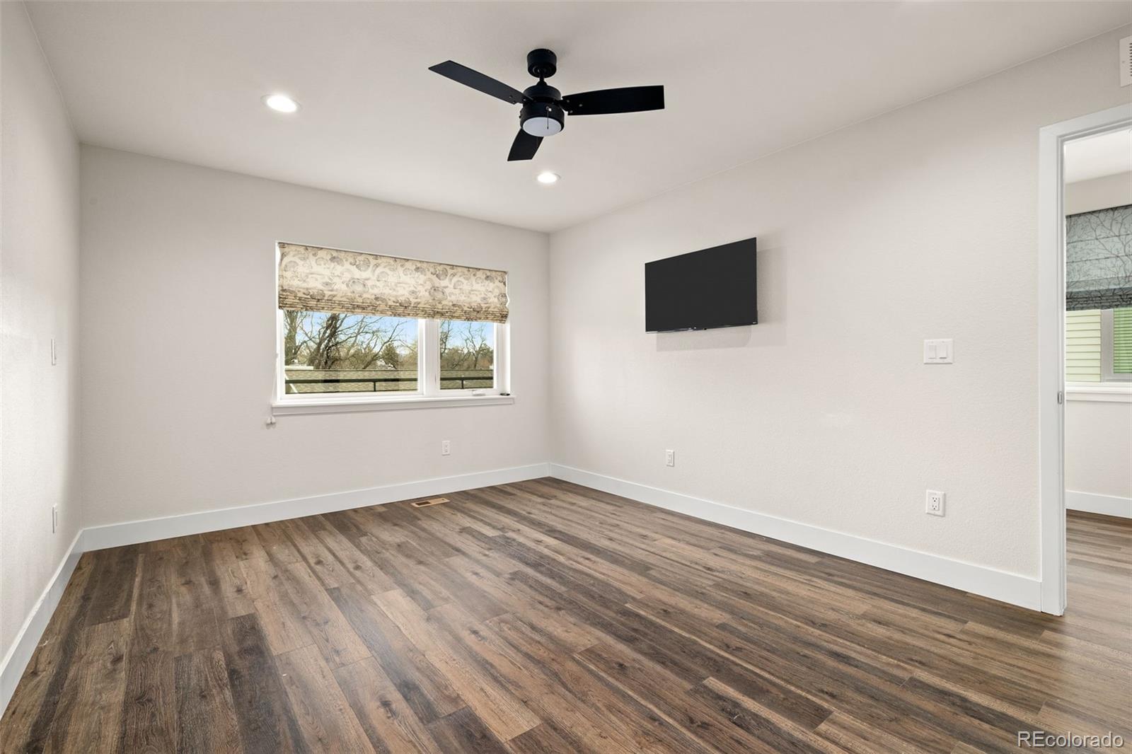 1204 South Reed Street Lakewood, CO 80232 - Photo 38 of 45 an empty room with wooden floor ceiling fan and window
