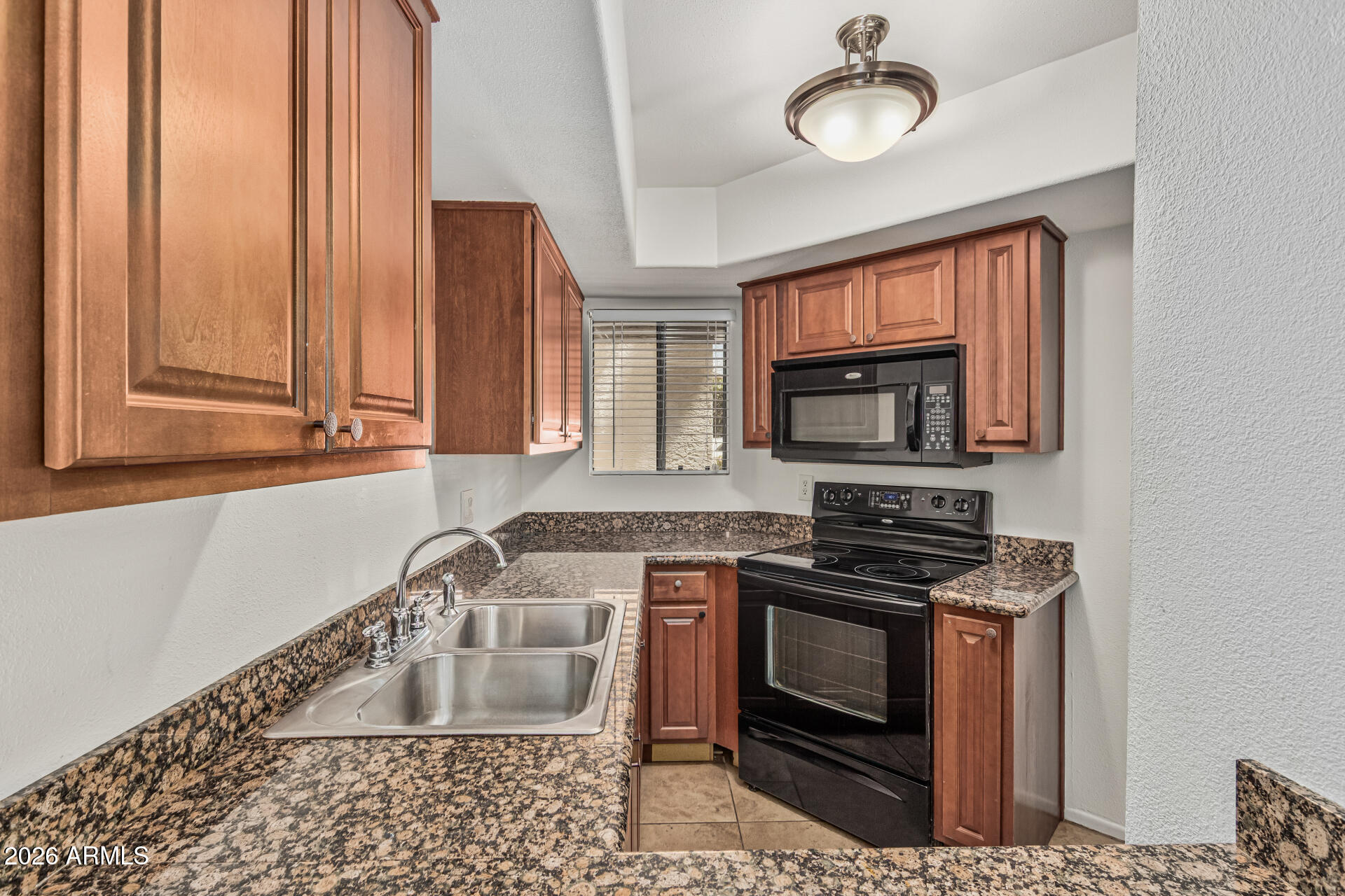 985 North Granite Reef Road, Unit 129 Scottsdale, AZ 85257 - Photo 16 of 38 a kitchen with stainless steel appliances granite countertop a stove a sink and a microwave