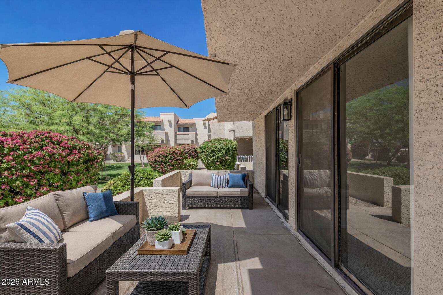 985 North Granite Reef Road, Unit 129 Scottsdale, AZ 85257 - Photo 7 of 38 a view of a patio with a table and chairs under an umbrella