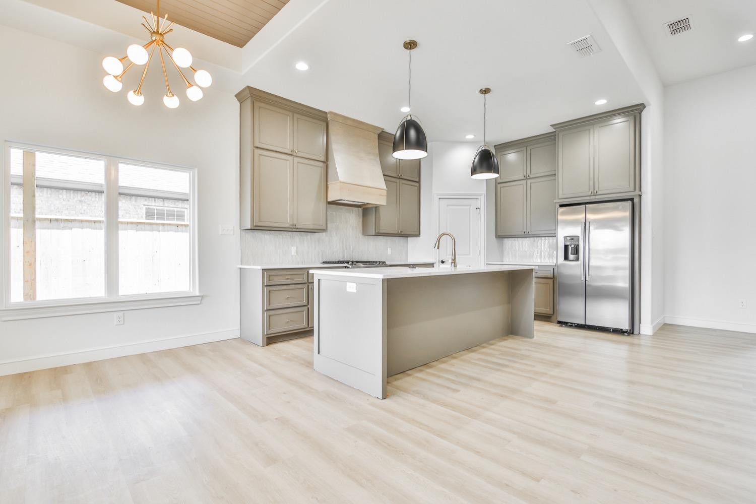 7616 53rd Street Lubbock, TX 79407 - Photo 9 of 50 a large kitchen with a large counter top a sink stainless steel appliances and cabinets