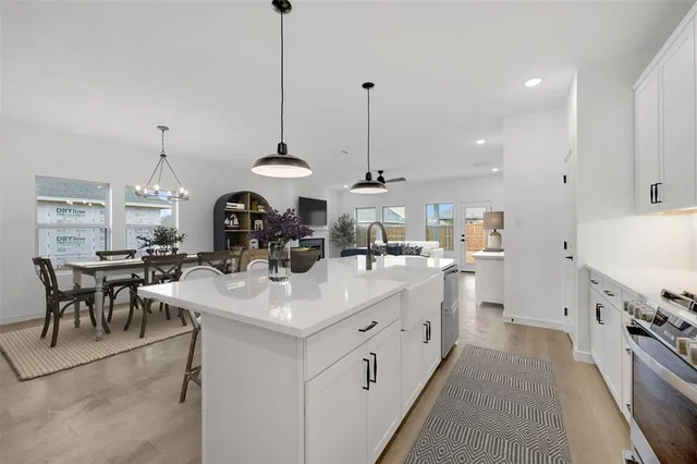 a kitchen with a sink a stove a refrigerator and white cabinets