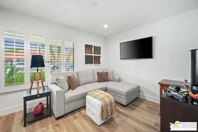 a living room with furniture and a wooden floor