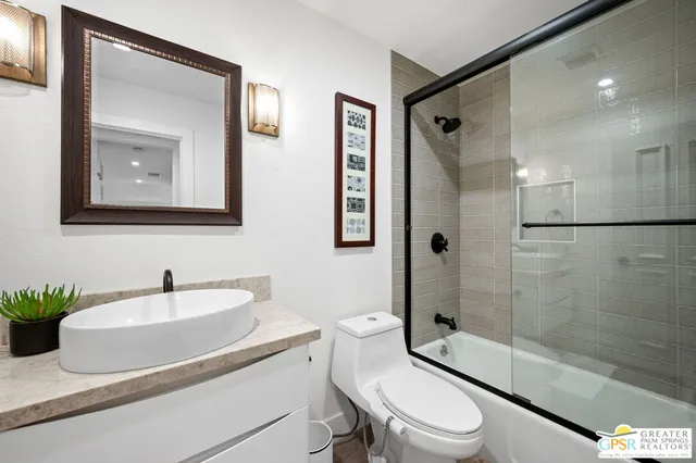 a living room with furniture a flat screen tv and a floor to ceiling window