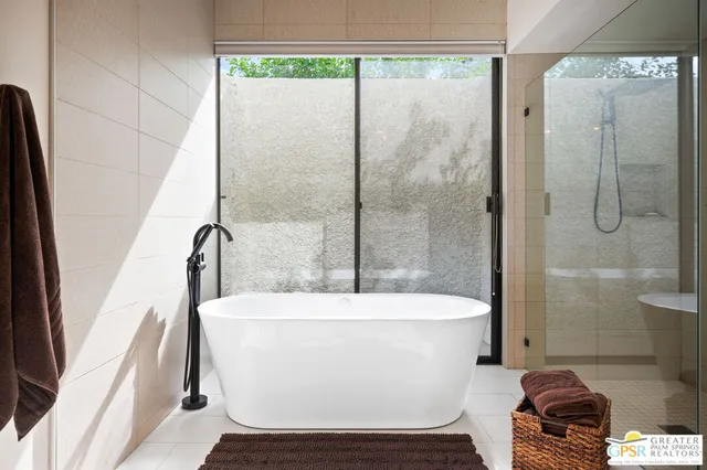 a view of a patio with couches table and chairs under an umbrella with a small yard