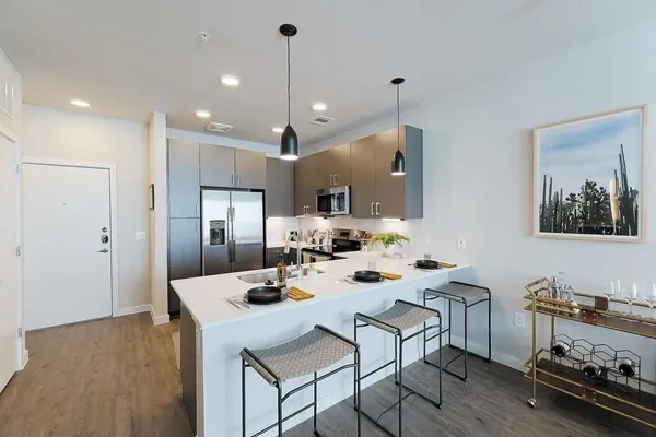 a view of a dining room and livingroom with furniture wooden floor a chandelier