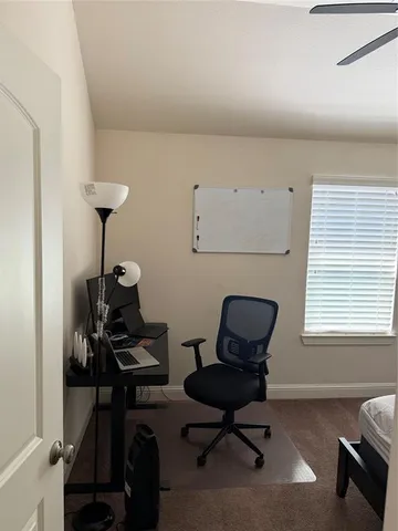 a view of a workspace with furniture and a window