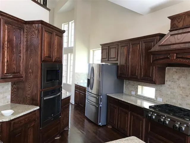 a kitchen with granite countertop stainless steel appliances and wooden cabinets