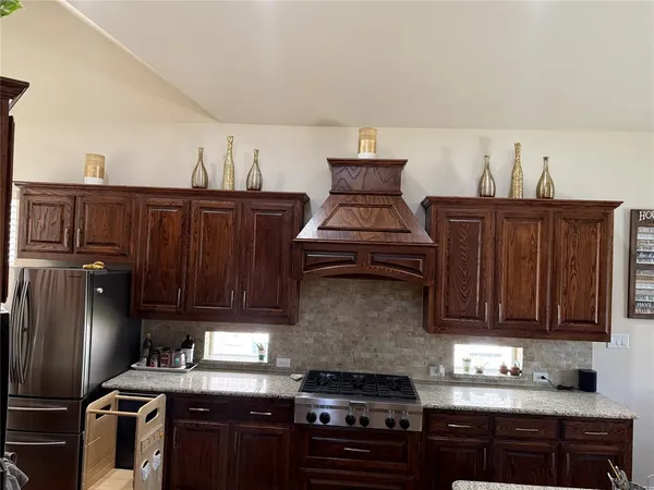 a kitchen with granite countertop a stove and a refrigerator