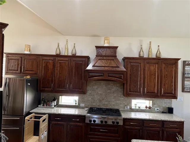 a kitchen with granite countertop a stove and a refrigerator