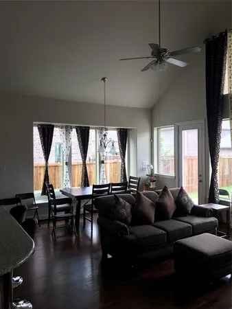 a living room with furniture a large window and a chandelier
