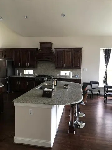 a kitchen with granite countertop a sink a stove and a wooden cabinets