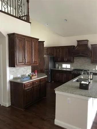 a kitchen with kitchen island granite countertop a sink stainless steel appliances and cabinets