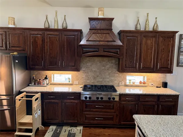 a kitchen with granite countertop a stove and a sink
