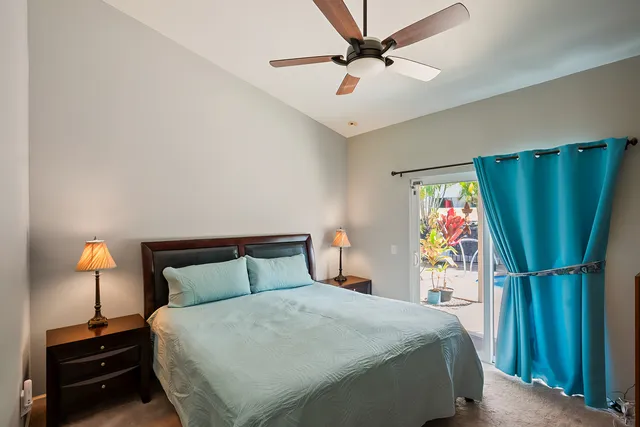 a bedroom with a bed and a flat tv screen on the dresser
