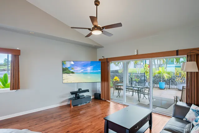 a living room with furniture a flat screen tv and a floor to ceiling window