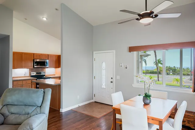 a living room with furniture a floor to ceiling window and wooden floor