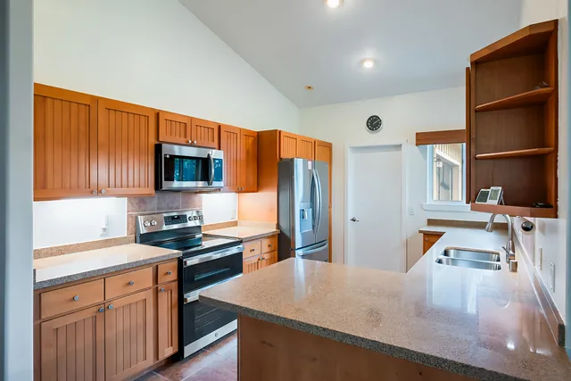 a kitchen with stainless steel appliances granite countertop a sink stove and refrigerator