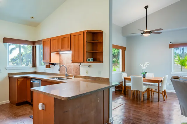 a kitchen with a sink a window and chairs