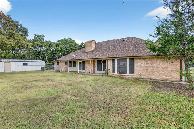 a front view of house with yard and trees in the background