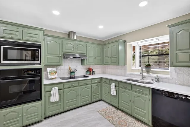 a kitchen with lots of counter top space sink and stainless steel appliances