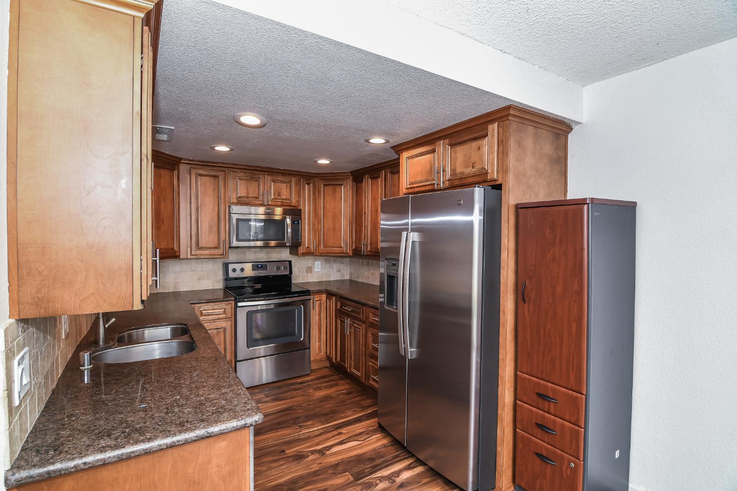 1139 Rivara Circle Sacramento, CA 95864 - Photo 20 of 72 a kitchen with stainless steel appliances granite countertop a refrigerator a stove and a sink with wooden floors