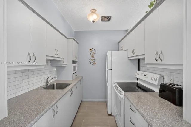 a kitchen that has a sink a stove and refrigerator