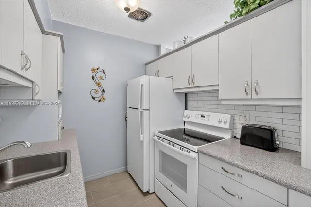 a kitchen with refrigerator cabinets and a sink