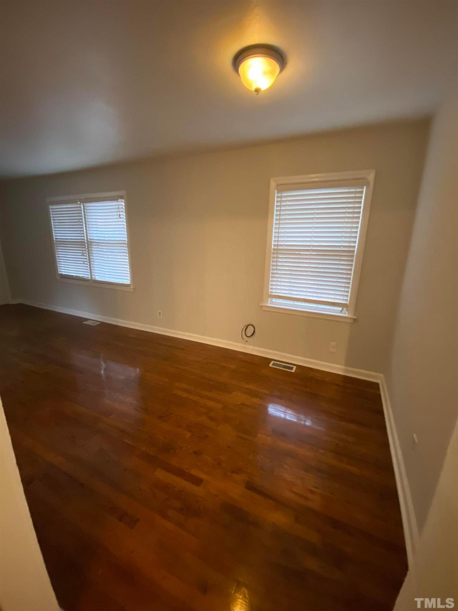 2418 Stevens Road Raleigh, NC 27610 - Photo 13 of 17 an empty room with wooden floor and windows