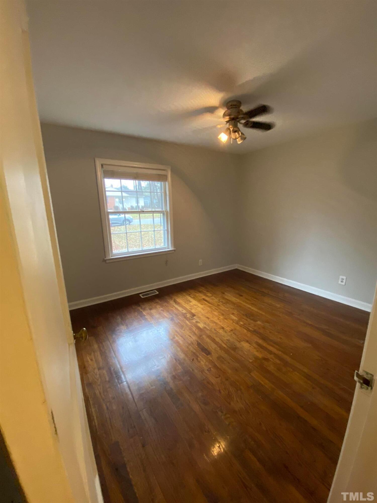 2418 Stevens Road Raleigh, NC 27610 - Photo 15 of 17 an empty room with wooden floor fan and windows