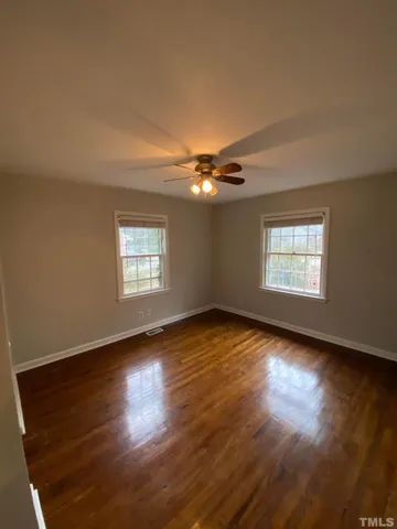 a view of an empty room window and wooden floor