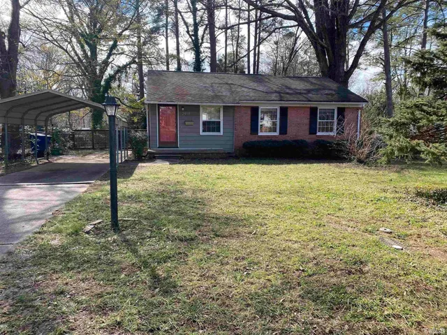 a brick house that has a tree in front of it