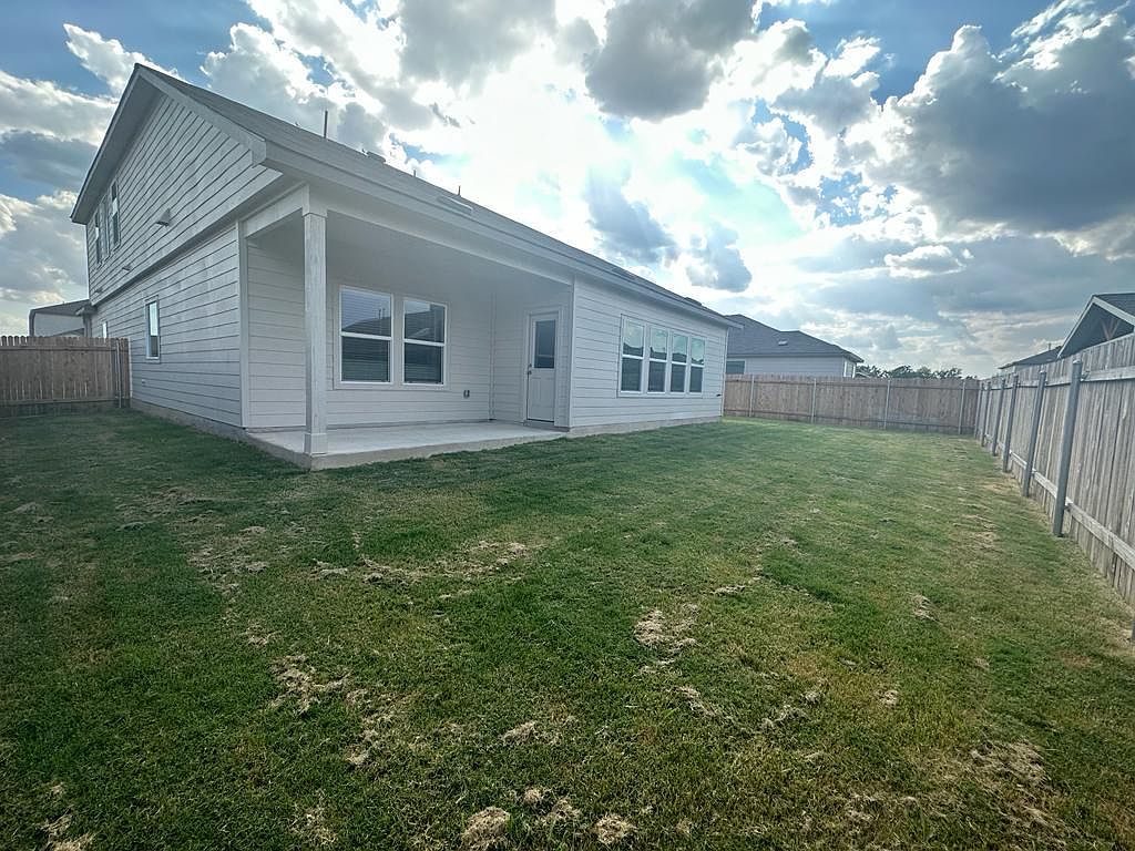 160 River Rise Road Kyle, TX 78640 - Photo 33 of 35 Expansive backyard featuring a covered patio, privacy fencing, and a two-story exterior with horizontal siding