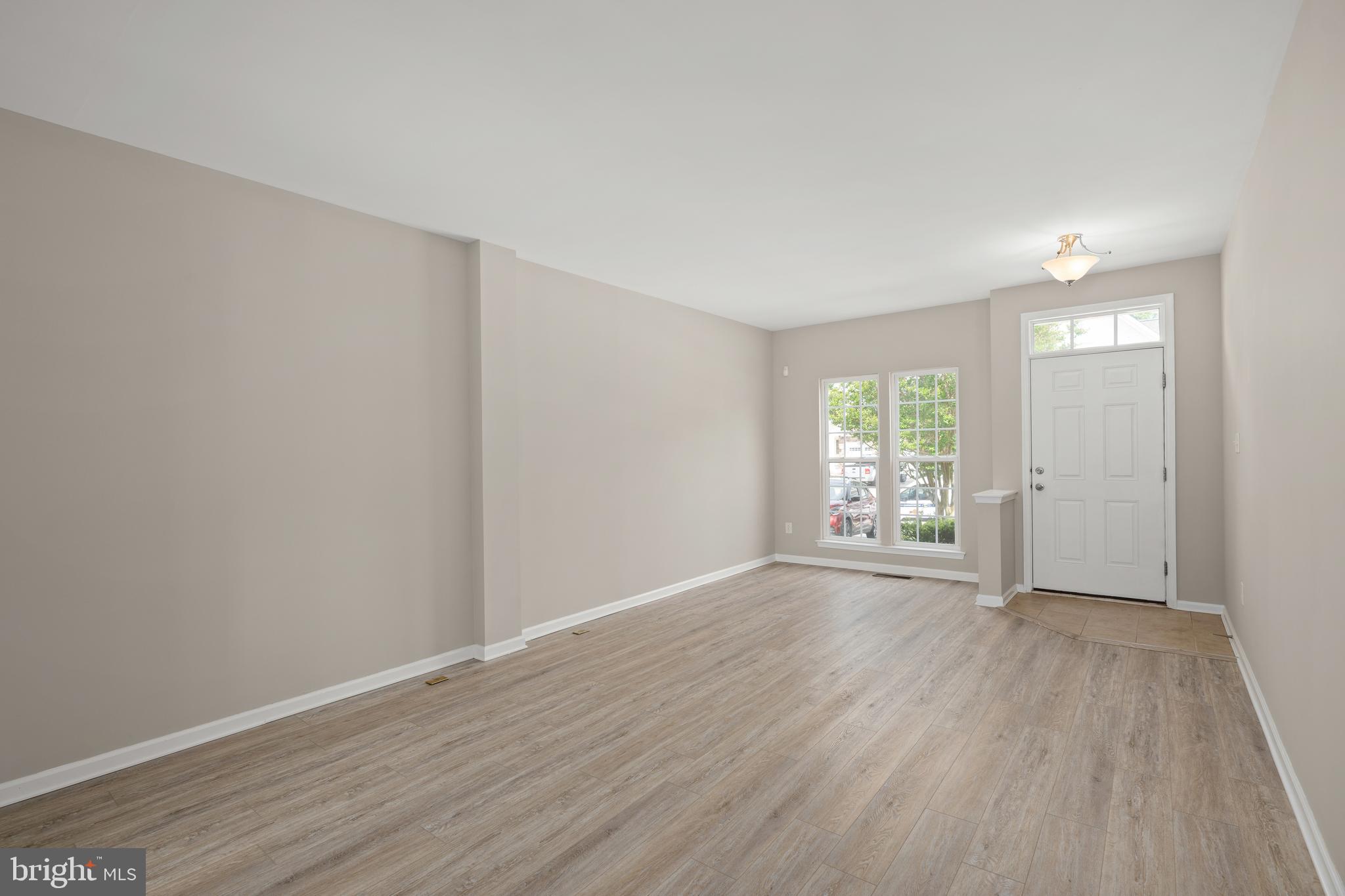 10023 Iron Pointe Drive Extension, Unit 201B2 Millsboro, DE 19966 - Photo 14 of 41 a view of an empty room with wooden floor and a window
