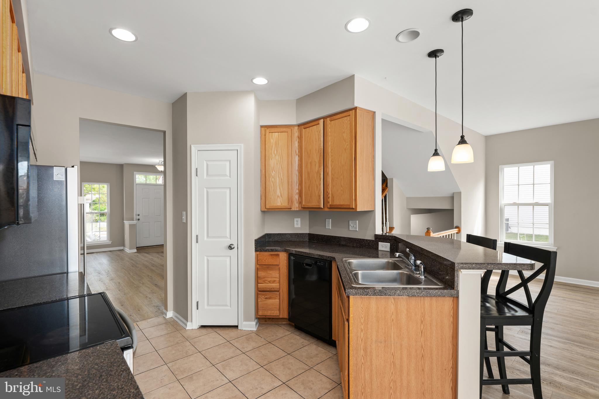 10023 Iron Pointe Drive Extension, Unit 201B2 Millsboro, DE 19966 - Photo 10 of 41 a kitchen with stainless steel appliances granite countertop a refrigerator a sink a stove and island