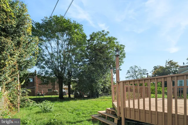 a view of a backyard with wooden fence and plants
