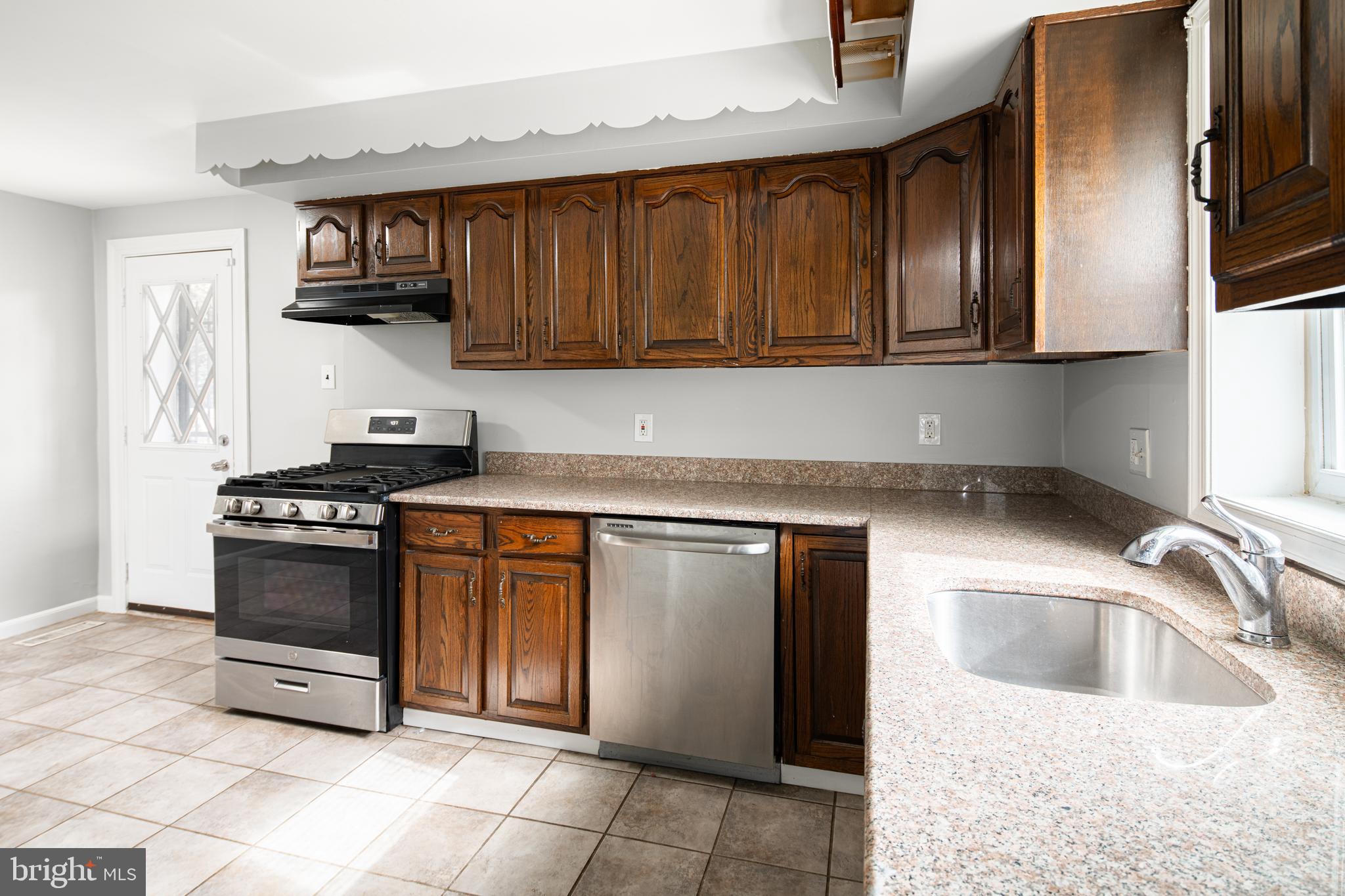 1625 Rhawn Street Philadelphia, PA 19111 - Photo 4 of 15 a kitchen with stainless steel appliances granite countertop a sink stove and refrigerator
