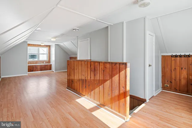 a view of a hallway with wooden floor and stairs