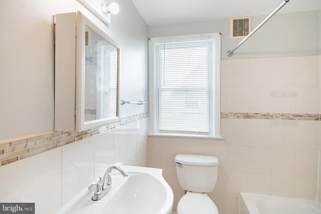 a bathroom with a sink a toilet and a window