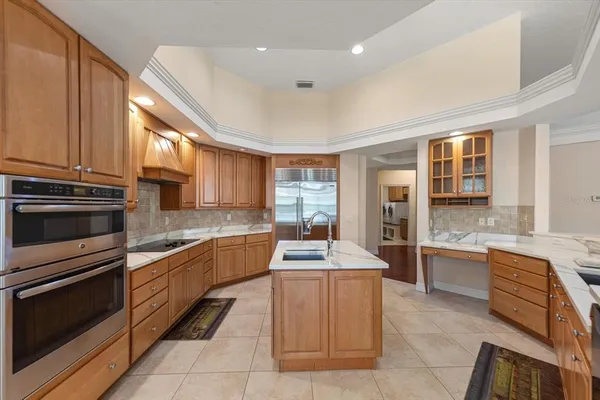 a kitchen with stainless steel appliances granite countertop a stove top oven a sink dishwasher a dining table and chairs with wooden floor