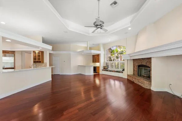 a view of a room with wooden floor fireplace and windows