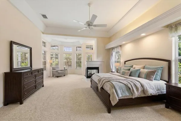 a spacious bedroom with a large bed and a chandelier