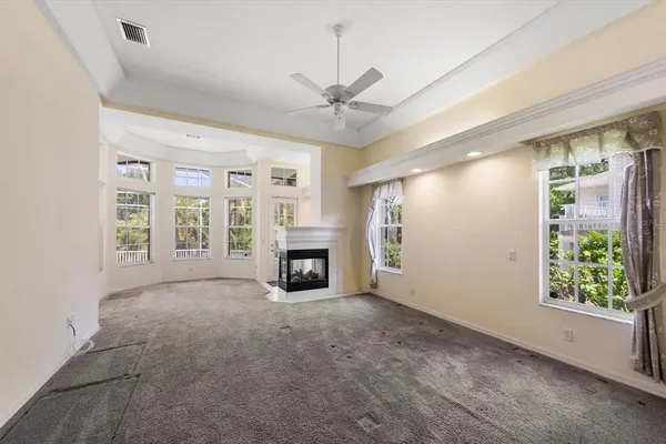 a view of an empty room with a fireplace and a window
