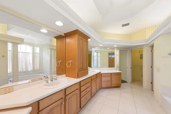 a spacious bathroom with a double vanity sink large mirror and a bathtub
