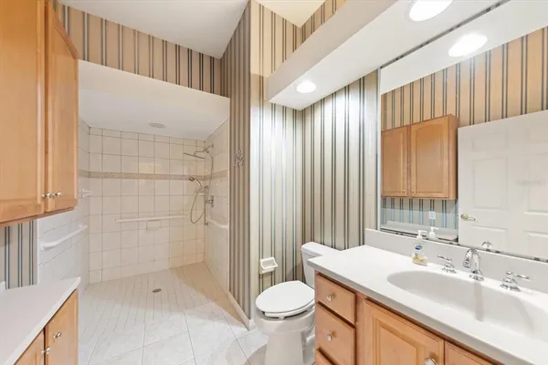 a bathroom with a sink a toilet and shower