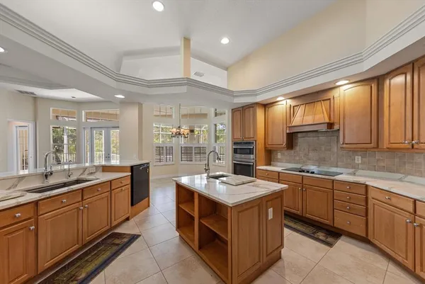 a kitchen with kitchen island granite countertop a sink stove and cabinets