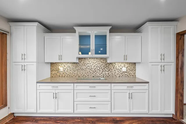 a kitchen with granite countertop white cabinets and white appliances
