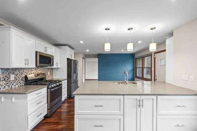 a kitchen with stainless steel appliances granite countertop a sink and a stove