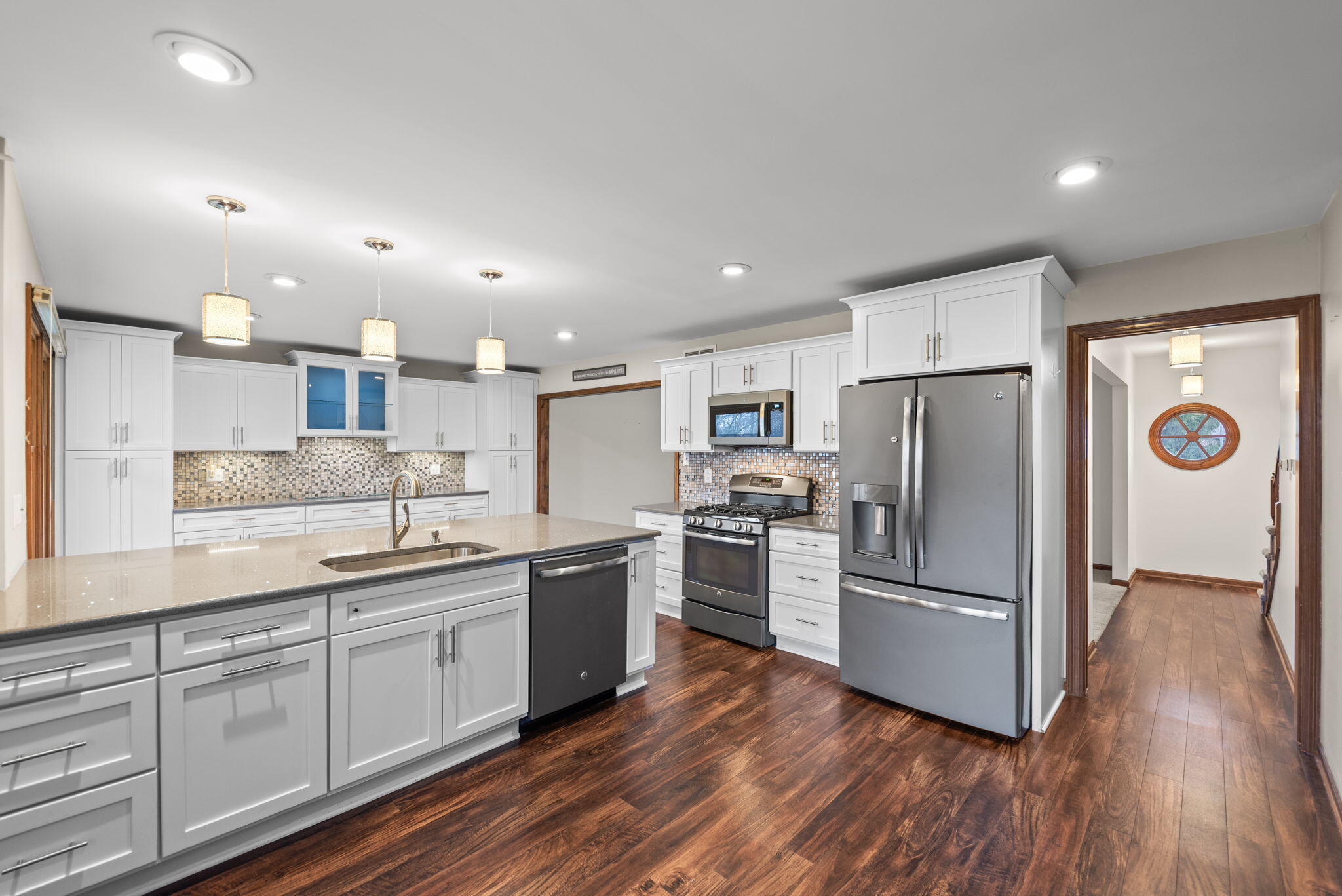 2595 West 65th Avenue Merrillville, IN 46410 - Photo 15 of 36 a kitchen with refrigerator cabinets and wooden floor