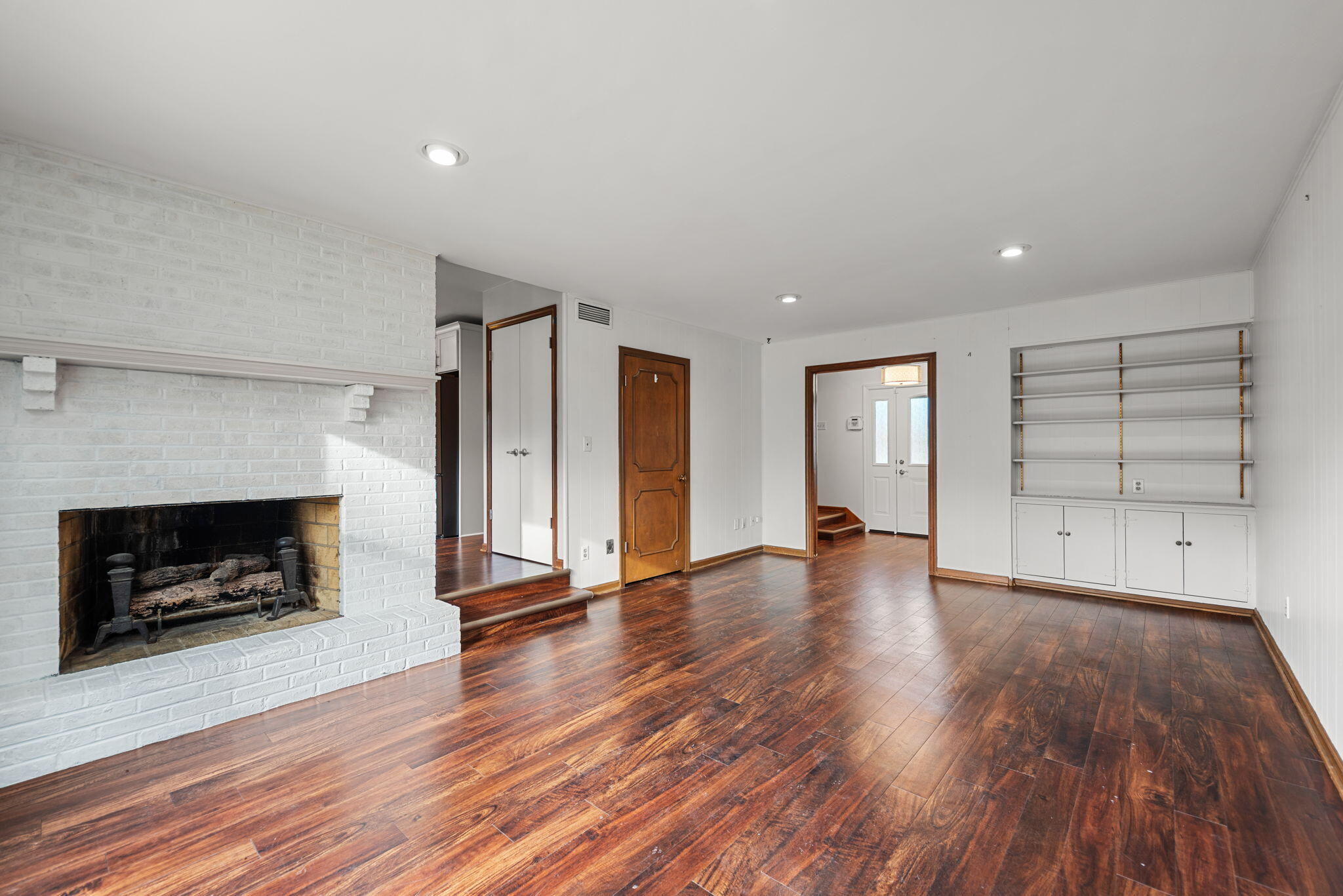 2595 West 65th Avenue Merrillville, IN 46410 - Photo 18 of 36 an empty room with wooden floor fireplace and windows